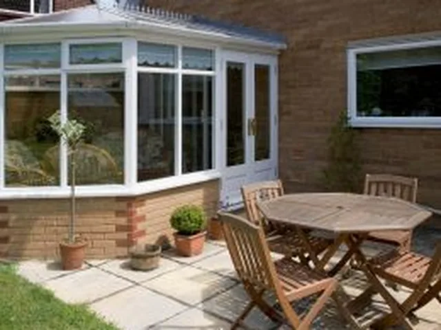 White uPVC conservatory installed by Secura Windows, opening onto a garden patio